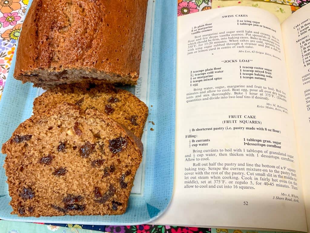 Jocks loaf sliced on blue tray with book opened to page of recipe.
