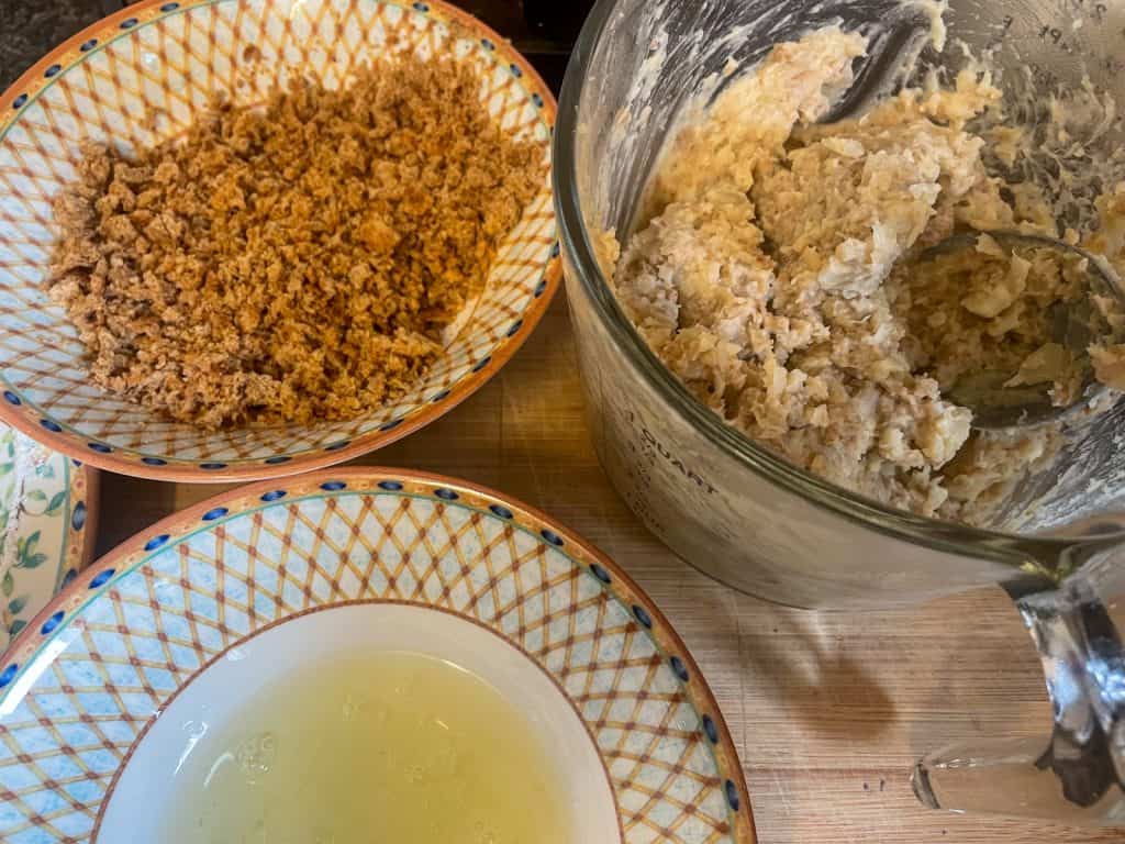 Bowls with breadcrumbs and egg white and bowl with white bean croquette mixture.
