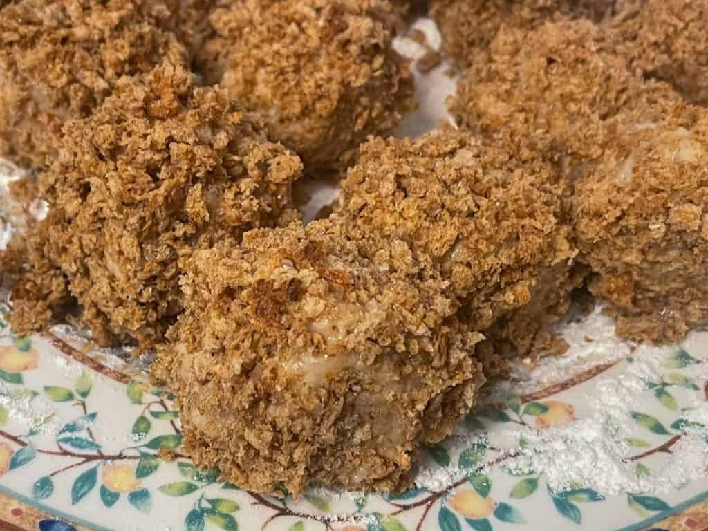 Croquettes formed and breaded and on a plate.