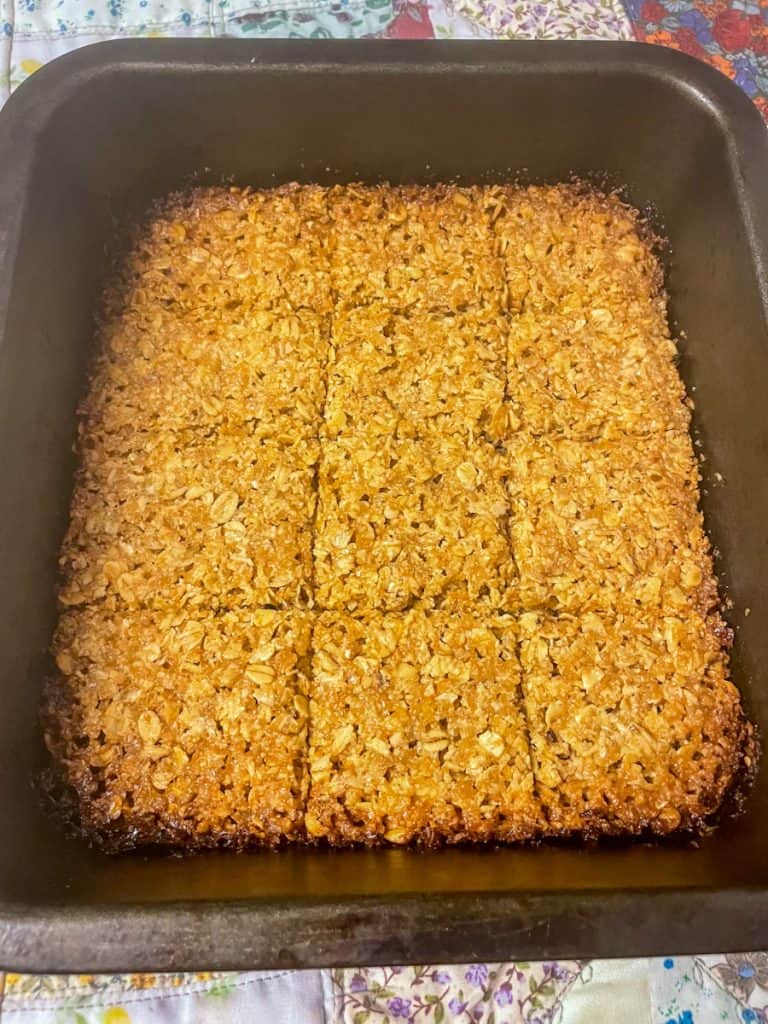Flapjacks scored into pieces in baking pan.